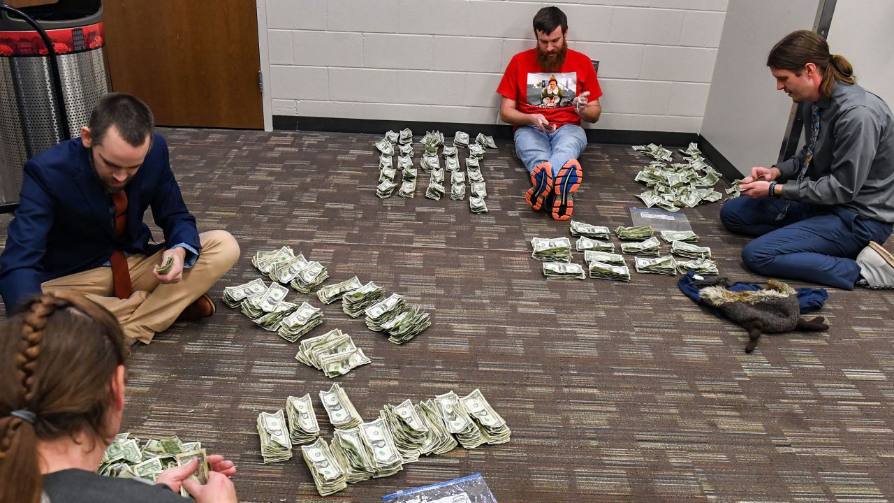Schoolteachers count the dollar bills they collected at the Sioux Falls Stampede game.