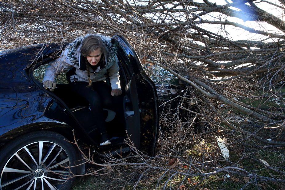 Hannah Binder climbs out of her car in Edwardsville, Illinois, on December 13. She was gathering some personal items from the car after it had been hit by a tree on Friday.