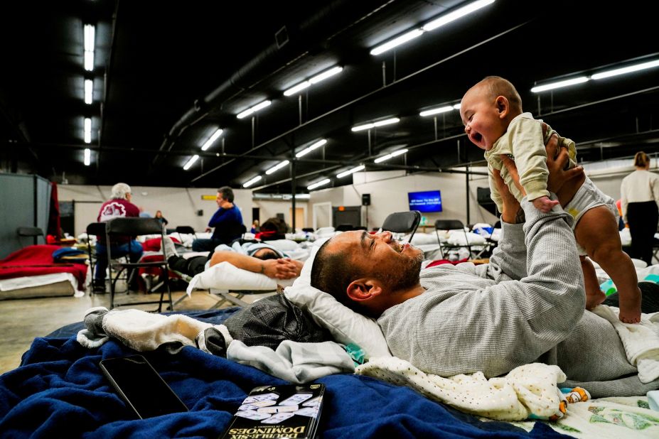Anthony Vasquez plays with his 4-month-old son, Michael, inside a makeshift shelter in Wingo, Kentucky, on December 13.