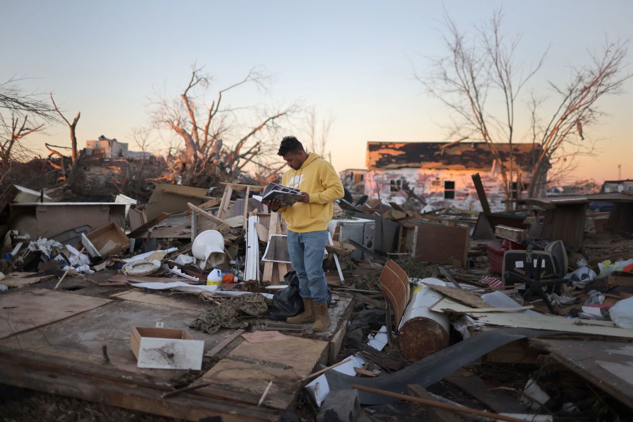 J'il Wimbley looks over his sister's high school yearbook, which he found in the remains of his father's home in Mayfield on December 13. Wimbley's father, who was the only one home at the time of the tornado, took cover under a dining table as the home collapsed.