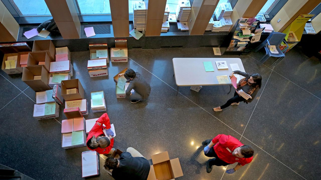 Boston Public School teachers and volunteers deliver printed packets for students to take home on March 16, 2020.