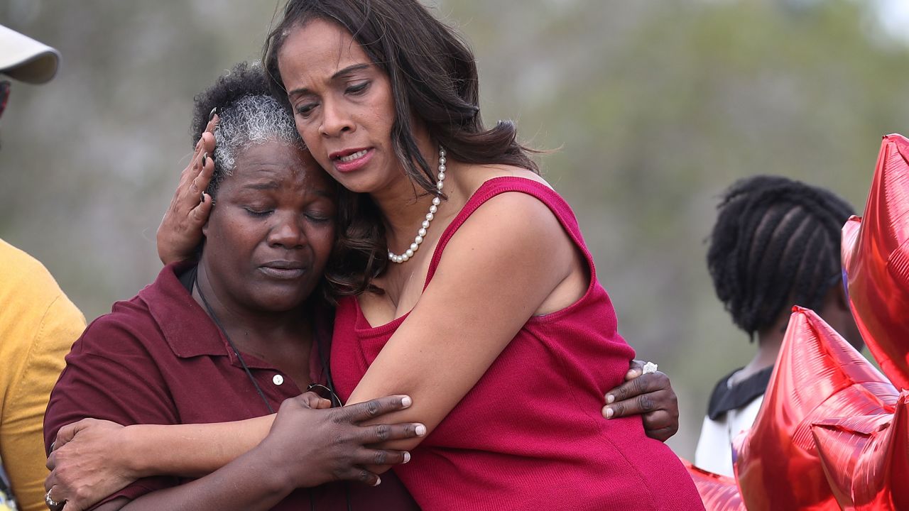 A school board member hugs a school bus driver as they return to Marjory Stoneman Douglas High School. It was the first time teachers and staff were allowed back at the school since the mass shooting in February 2018.