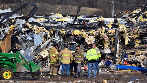 Emergency response workers dig through the rubble of the Mayfield Consumer Products candle factory in Mayfield, Kentucky, on Saturday