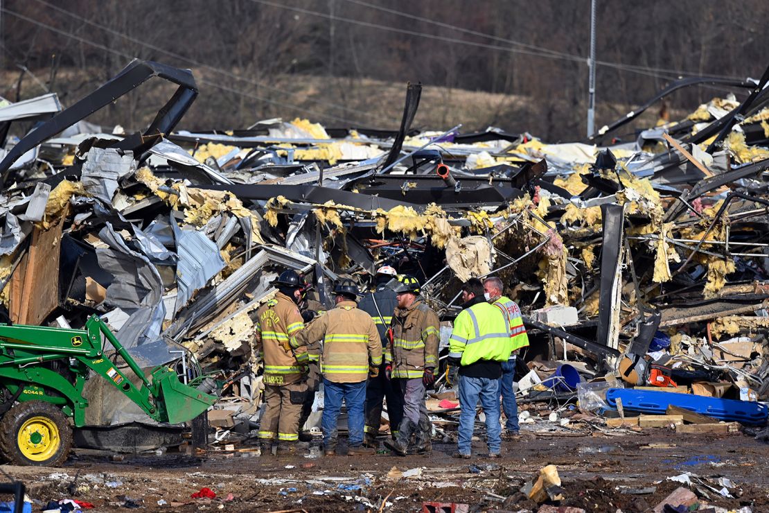 Emergency response workers dig through the rubble of the Mayfield Consumer Products candle factory in Mayfield, Kentucky, on Saturday