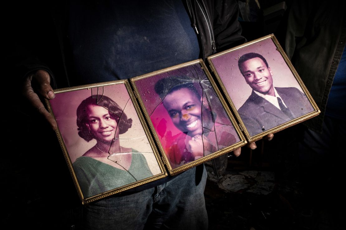 Jason White holds family photos he salvaged from his home in Mayfield, Kentucky.