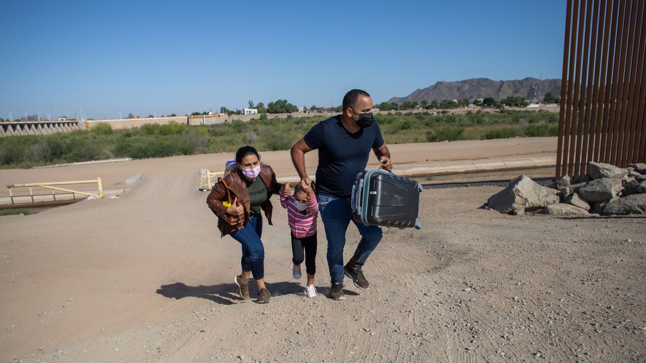 A Cuban family seeking asylum in the United States cross an open section of the border wall at the US-Mexico border in Yuma, Arizona, in May.