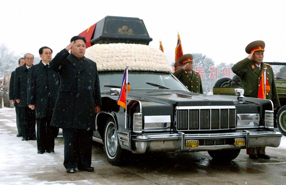 Kim Jong Un salutes beside his father's hearse during his funeral procession in Pyongyang on December 28, 2011.