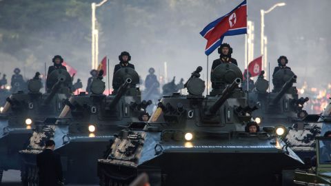 North Korean soldiers ride atop armored vehicles during a military parade in Pyongyang on October 10, 2015.