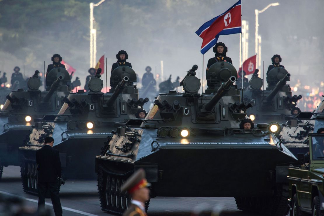 North Korean soldiers ride atop armored vehicles during a military parade in Pyongyang on October 10, 2015.  