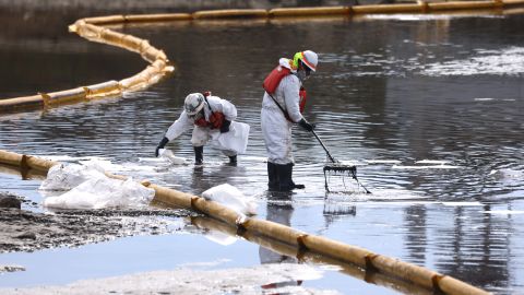 Workers in protective suits clean oil in the Talbert Marsh wetlands after a 126,000-gallon oil spill from an offshore oil platform on October 4, 2021 in Huntington Beach, California.
