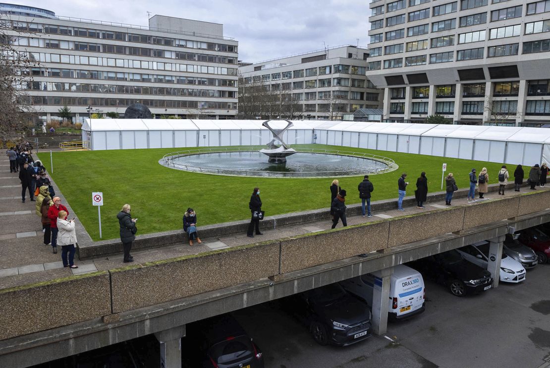 People line up for booster shots outside a vaccination center at London's St. Thomas Hospital on December 15, 2021.