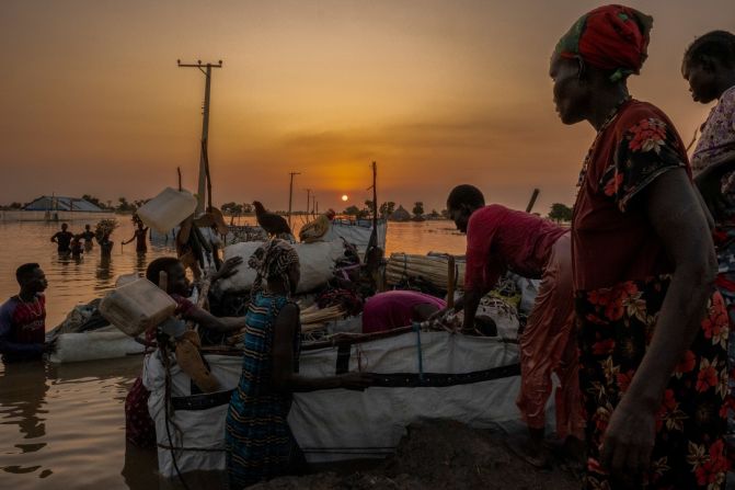 People work to get their possessions and livestock to higher ground before nightfall.