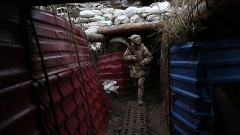 A Ukrainian serviceman walks out of a dugout on the frontline with Russia-backed separatists in December. 