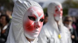 A protester wears a mask depicting syringes during a rally against coronavirus measures, Covid-19 health pass and vaccination in Geneva on October 9, 2021.