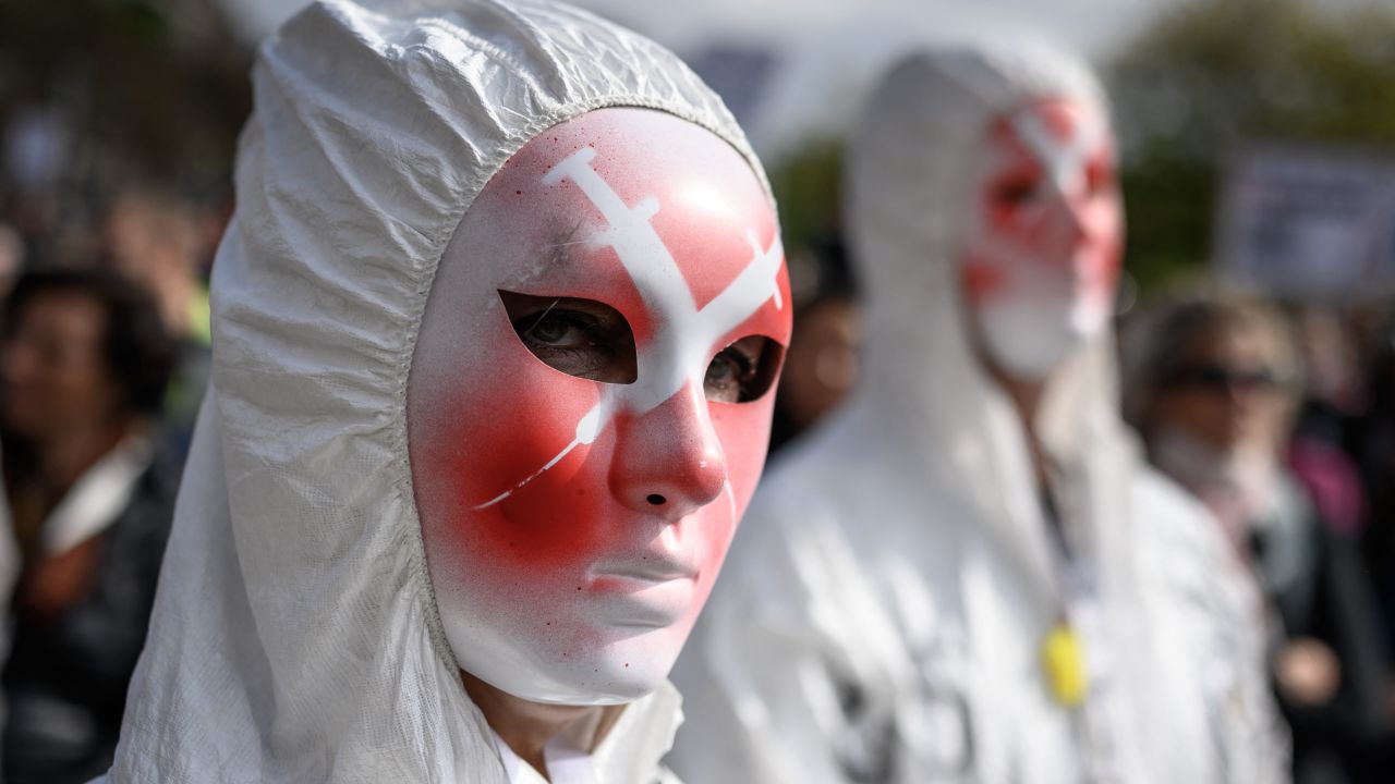 A protester wears a mask depicting syringes during a rally against coronavirus measures in Geneva on October 9, 2021.