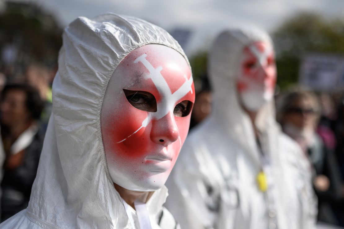 A protester wears a mask depicting syringes during a rally against coronavirus measures, Covid-19 health pass and vaccination in Geneva on October 9, 2021.