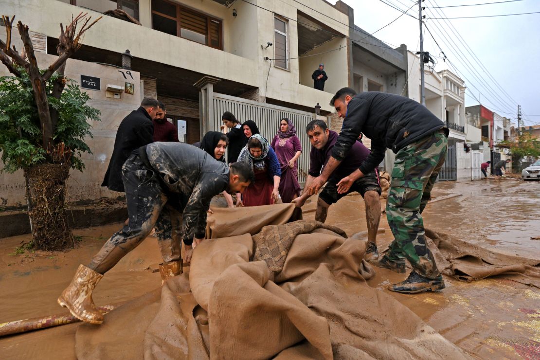 Residents in Erbil's Daratu district clear debris from flash floods caused by torrential rains.
