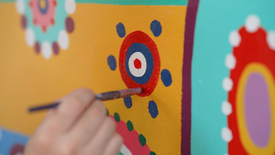 An artist touches up a detail at the Rainbow Village.