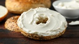 Bagels sandwich with cream cheese on wooden table.