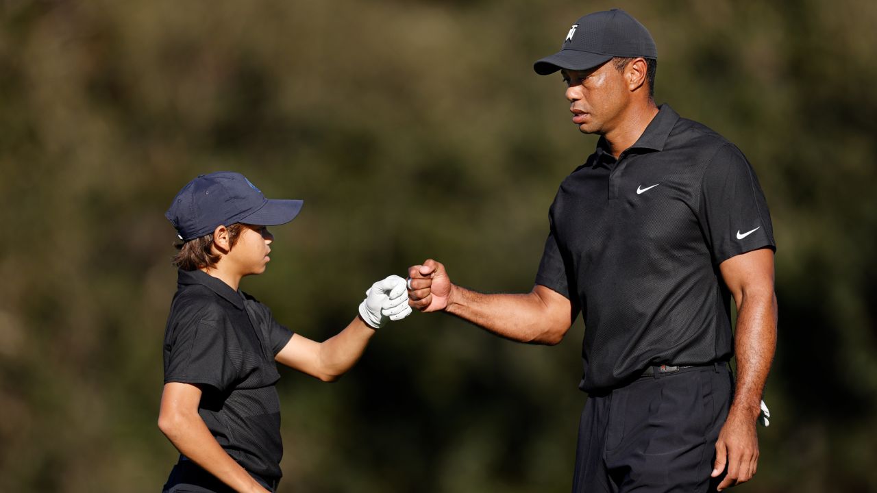 Tiger Woods and son Charlie Woods fist bump during the pro-am ahead of the PNC Championship on December 17, 2021.