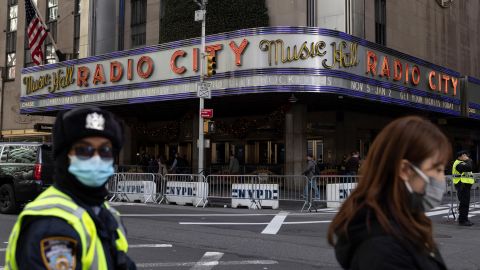 People stand in front of Radio City Music Hall after cancellations of The Rockettes performance due to Covid-19 on Friday, December 17, 2021, in New York.