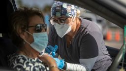 MIAMI, FLORIDA - DECEMBER 16: A healthcare worker administers a Pfizer-BioNTech COVID-19 vaccine to a person at a drive-thru site in Tropical Park on December 16, 2021 in Miami, Florida.  Miami-Dade County Mayor Daniella Levine Cava visited the vaccination site to encourage residents to take holiday gatherings outside this year, get tested for COVID-19, and get vaccinated. (Photo by Joe Raedle/Getty Images)