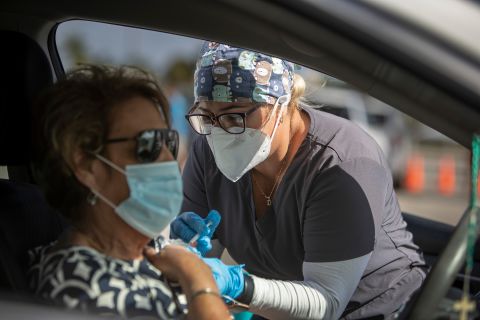 A health-care worker administers a vaccine to a person at Miami's Tropical Park on December 16.