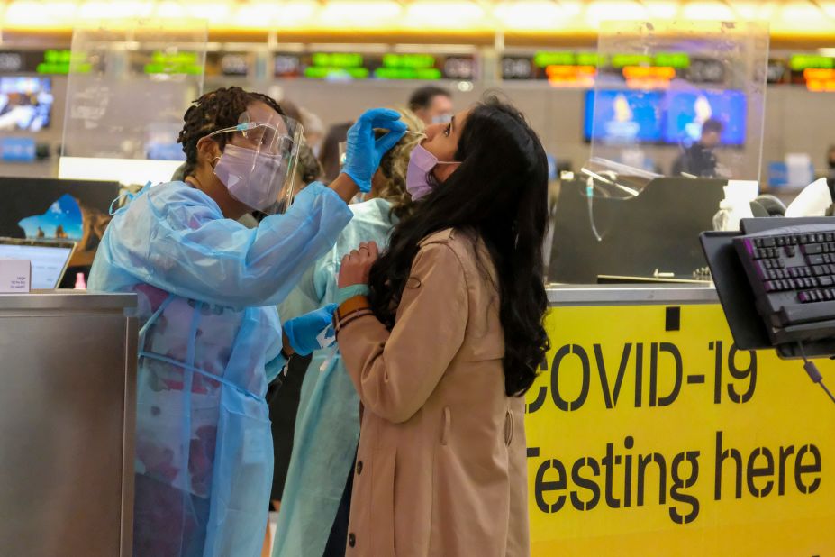 A nurse collects a nasal swab sample from a traveler at a Covid-19 testing site at the Los Angeles International Airport on December 10.