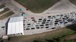 MIAMI, FLORIDA - DECEMBER 17:  In an aerial view, cars line up at a drive-thru COVID-19 testing site at Tropical Park on December 17, 2021 in Miami, Florida. Healthcare workers are urging people to take precautions during family holiday get-togethers as COVID-19 cases rise. (Photo by Joe Raedle/Getty Images)