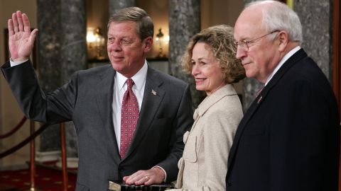 US Senator Johnny Isakson (R-GA) poses for photographers with his wife, Dianne, and Vice President Dick Cheney (R) during the reenactment of a swearing-in ceremony January 4, 2005, on Capitol Hill in Washington, DC.