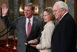 US Senator Johnny Isakson (R-GA) poses for photographers with his wife, Dianne, and Vice President Dick Cheney (R) during the reenactment of a swearing-in ceremony January 4, 2005, on Capitol Hill in Washington, DC. 