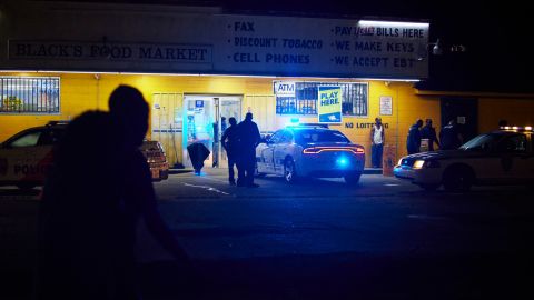Police respond to a shooting outside a food market in Jackson. The city recently raised starting pay for new police officers to  $30,000 per year.