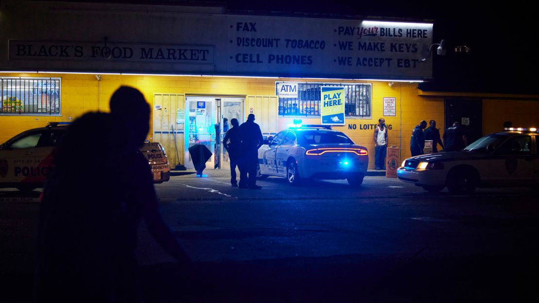Police respond to a shooting outside a food market in Jackson. The city recently raised starting pay for new police officers to $30,000 per year.