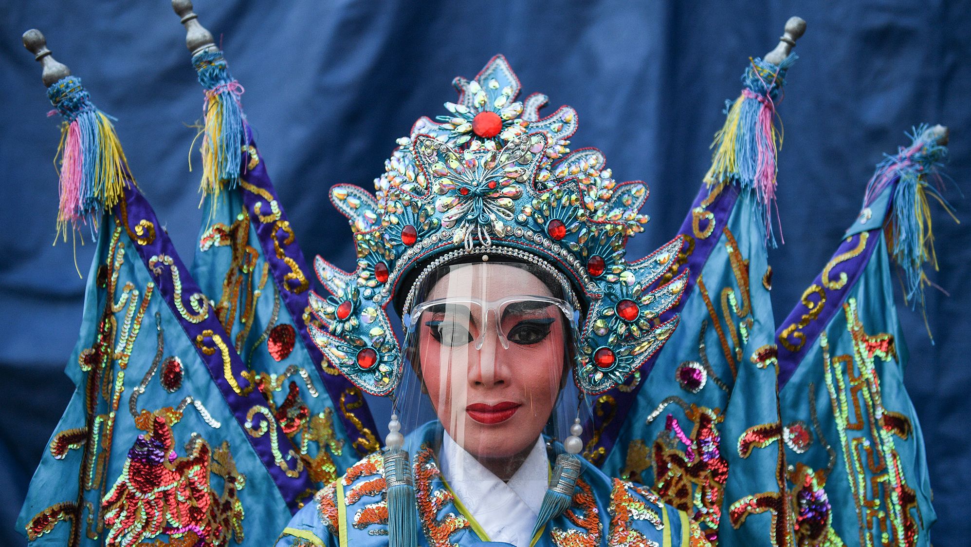 <strong>Chalinee Thirasupa, based in Bangkok, Thailand:</strong> A traditional Chinese Opera performer gets ready before a live performance, on the evening of Lunar New Year in Bangkok, Thailand.  <br /> <br />The opera has long been a colorful staple of Bangkok life. The ancient art form, combining literature and musical performance, is one of the oldest performance arts in the world, with roots going back to the Tang Dynasty.  <br /> <br />The day I took the picture was the very first time the Thai government allowed public performances with social distancing and Covid-19 safety procedures. Everyone had to wear face shields and follow all the protocols but participated in order to survive the financial crisis, because there had been no work for them for about a year.  <br /> <br />We cannot escape the endless war against the pandemic, our lives will never ever be the same. However, we're learning to live with it instead and go on in order to survive.  