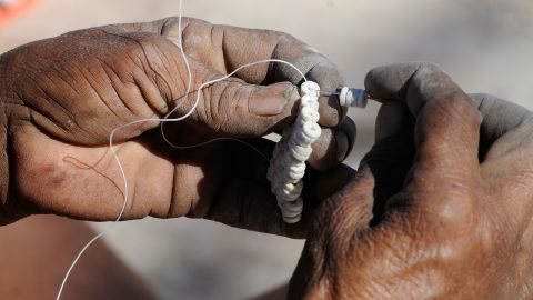 Ostrich eggshell beads being strung together.