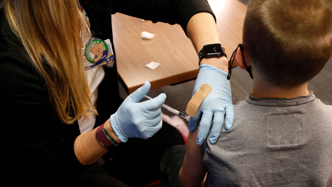 A 8 year-old child receives their first dose of the Pfizer Covid-19 vaccine at the Beaumont Health offices in Southfield, Michigan on November 5, 2021.