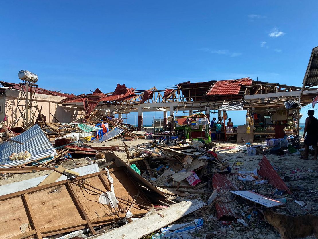 Residents stand next to a destroyed market building in General Luna town, Siargao island, Surigao del Norte province, a day after Typhoon Rai devastated the island.  