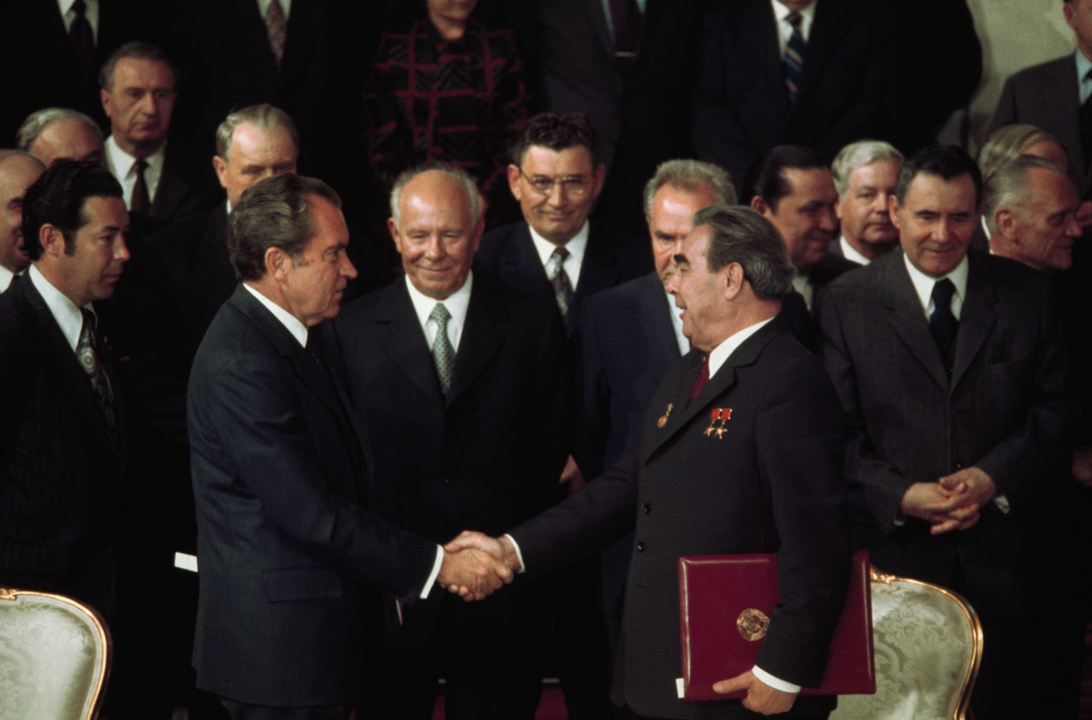 With Kremlin leaders and Presidential aides looking on, US President Richard Nixon shakes hands with Communist Party Chairman Leonid Brezhnev after signing one of several agreements made during their seven-day summit in 1974.