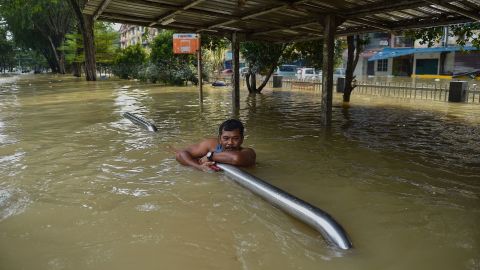 A man holds onto barriers as he waits to be evacauted by a rescue team in Shah Alam, Selangor, Malaysia, on December 20.