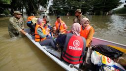 Rescuers evacuate residents on a boat in a flooded housing area in Shah Alam, outskirts of Kuala Lumpur, Malaysia, Monday, Dec. 20, 2021. Rescue teams on Monday worked to free people trapped by Malaysia's worst flooding in years after heavy rains stopped following more than three days of torrential downpours in the capital and around the country. (AP Photo/Vincent Thian)