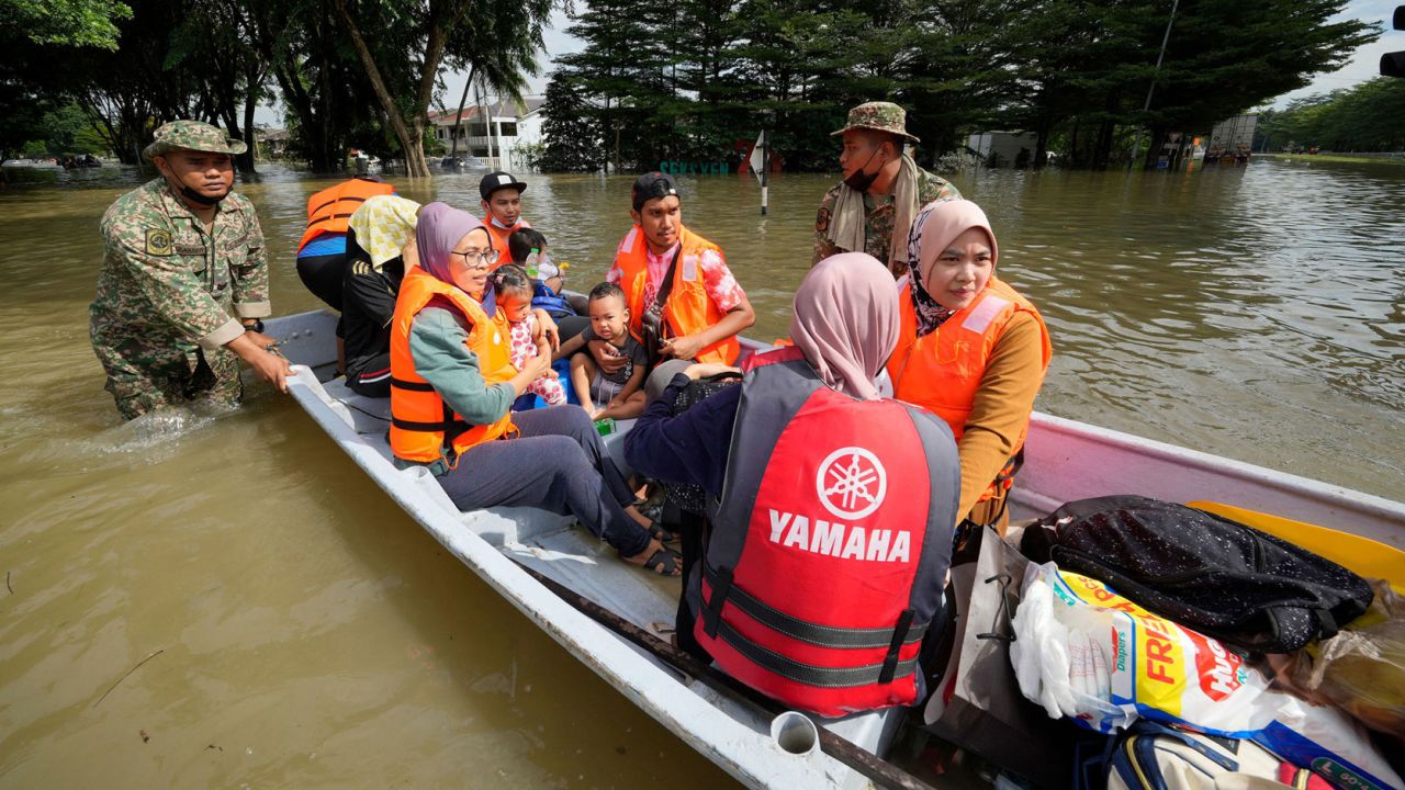 Rescuers evacuate residents on a boat in Shah Alam, Malaysia, on December 20.