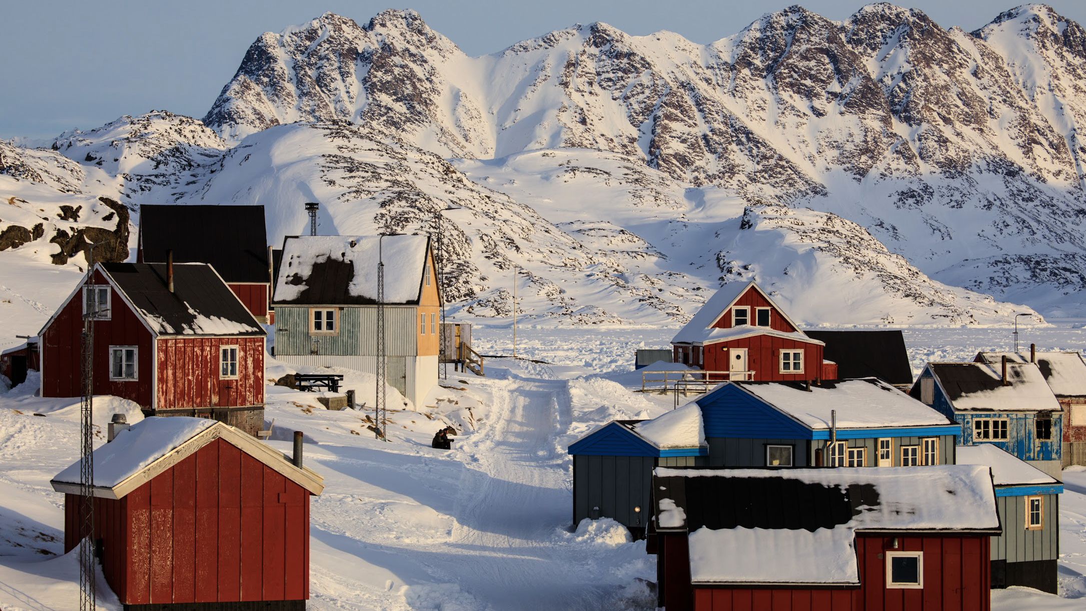 Downtown Kulusuk, Greenland, where winter now starts several weeks later and ends sooner. Nearby, one of the fastest- moving glaciers in the world, the Helheim Glacier, flows at more than 70 feet a day, dumping millions of tons of ice into the ocean. 