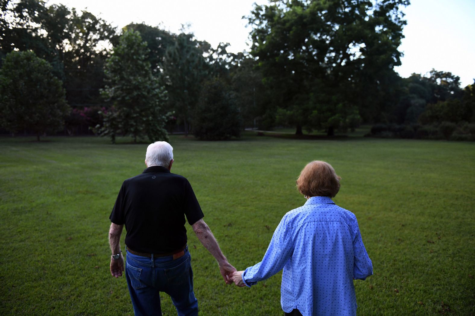 The Carters walk home together after having dinner at a friend's home in Plains in 2018.