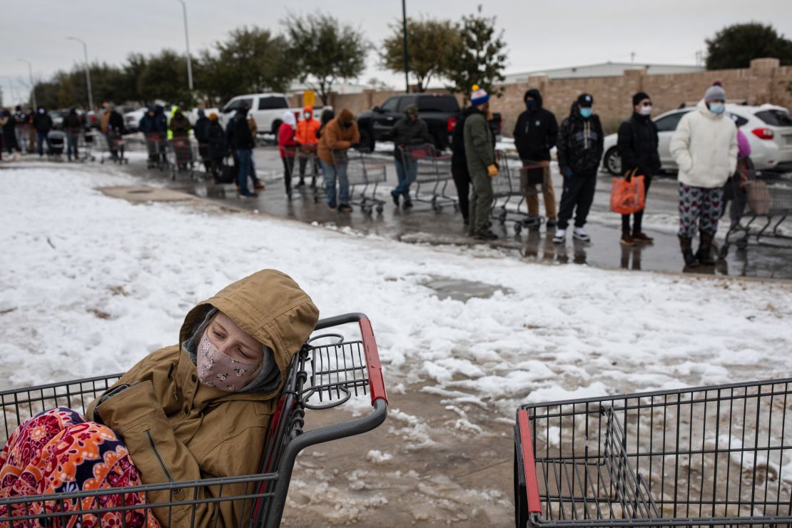 Camilla Swindle, 19, sits in a shopping cart as she and her boyfriend wait in a long line to stock up at a grocery store in Austin, Texas, on February 16, 2021. 