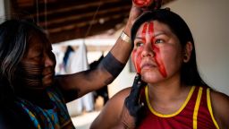 Indigenous leader and first female chief, O.E. Paiakan Kayapo, 38 yrs, has her face painted by her aunt, Tuire Kayapo—who was one of the first outspoken indigenous women about the harmful effects of climate change on the indigenous communities and land--at home with her family in Redencao, in  the state of Para, in Brazil, September 23, 2021. O-é Kaiapó Paiakan, a member of the Mebêngôkre people in the Kayapó tribe of
Brazil, is one of those women. When her father, the iconic Kayapó leader Paulinho
Paiakan, passed away from Covid-19 in June 2020, the 38-year-old took on the reins
as a female tribal chief in March this year and is currently carrying her father's legacy
as one of the greatest pioneers of Brazil's Indigenous environmental movement.
Paiakan said Indigenous women have always been powerful, but as climate and
environmetnal threats worsen, their roles are changing too. They are stepping out of
the confines of their homes to attend college, find their voice, and take up male-dominated spaces, "Kayapó women have always fighting," she said. "From us, resistance is born. From
us come men, children, life. The woman completes herself with nature, and we have
always been part of the resistance along with the men."


