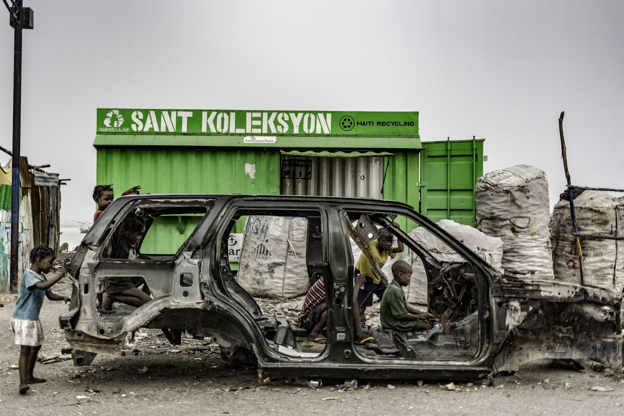 Children play in a burned out car in Haiti.