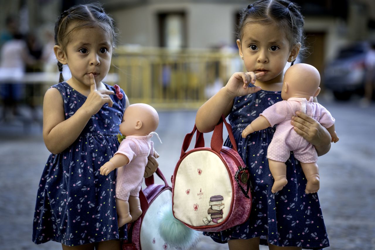 Two girls in Spain holding dolls, a recurring theme in Farese's photos. 