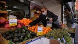 A shopper reaches for produce at a grocery store on a street in New York, New York on December 10, 2021.