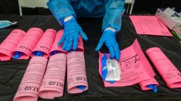 A healthcare worker arranges Covid-19 testing kits at an Essex County site in West Orange, New Jersey, New Jersey, U.S., on Tuesday, Dec. 21, 2021. New Jersey on Tuesday reported another 34 confirmed COVID-19 deaths and 6,840 confirmed cases, driving the states seven-day average for new positive tests above 6,000 for the first time during the pandemic, reports New Jersey Advance Media. Photographer: Christopher Occhicone/Bloomberg via Getty Images