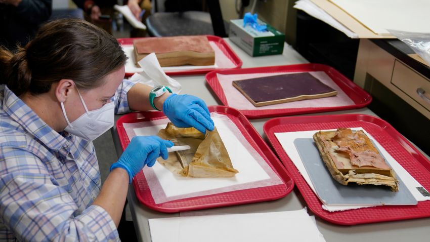 Sue Donovan, conservator for Special Collections at the University of Virginia, works on an envelope that was removed from a time capsule that was removed from the pedestal that once held the statue of Confederate General Robert E. Lee on Monument Ave. Wednesday Dec. 22, 2021, in Richmond, Va. Three books and an envelope with a photo were inside the box. (AP Photo/Steve Helber)